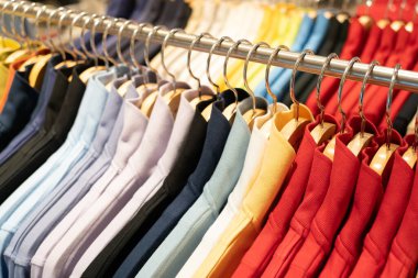 Seçici odak, moda, kıyafet konsepti, giysi ya da pantolon tasarımcı giyim mağazasında raflarda asılı. Bir mağazada elbise askısında asılı..
