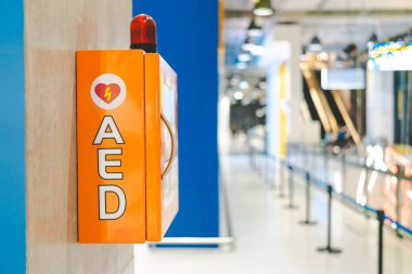 Alışveriş merkezinin duvarında talimatlar yazan otomatik dış defibrilatör kutusu AED makinesi.