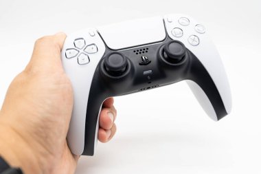 Playstation 5 Dual Sense kumandası, izole edilmiş arka planda erkek elde. PS5 denetleyicisini tutan kişi.