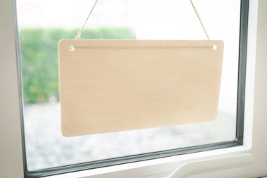 Pencereye asılı boş tahta tabela. Kapı camından mesaj için geniş bir imza atın. Boşluğu kopyala