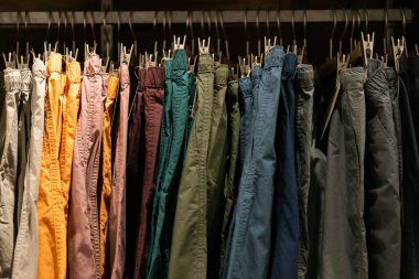 Moda, kıyafet konsepti, giysi ya da pantolon tasarımcı giyim mağazasında bir rafta asılı. Bir mağazada elbise askısında asılı..