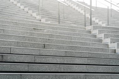 Soyut merdivenler siyah beyaz, soyut basamaklar, şehirde merdivenler. Geniş, pürüzsüz beton merdivenleri ve parlak paslanmaz çelik tırabzanları olan modern bir merdiven..