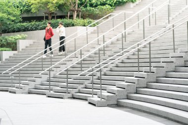 Soyut merdivenler siyah beyaz, soyut basamaklar, şehirde merdivenler. Geniş, pürüzsüz beton merdivenleri ve parlak paslanmaz çelik tırabzanları olan modern bir merdiven..