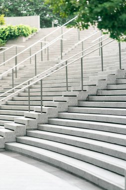 Soyut merdivenler siyah beyaz, soyut basamaklar, şehirde merdivenler. Geniş, pürüzsüz beton merdivenleri ve parlak paslanmaz çelik tırabzanları olan modern bir merdiven..