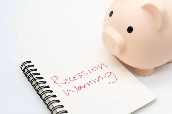 stock image Hand writing Recession Warning on notebook with piggy bank. Global economic crisis. Recession business and stock crisis concept.