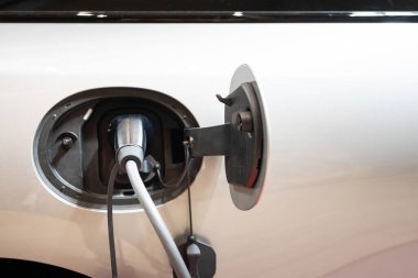 Elektrik kablosu tıkanmış bir şekilde şarj istasyonundaki EV Car veya Electric Car. Yeşil enerji ve eko enerji üretimi kavramında elektrikli araba şarj istasyonu.