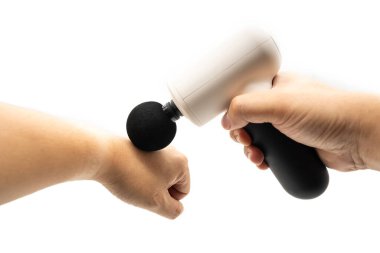 Elle masaj yapan erkek bir masaj tabancası. Kas gevşemesi için modern masaj silahı. Perküsyon masaj aleti.