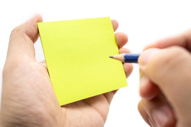 Beyaz arkaplana izole edilmiş boş bir nota yazmak. Yapışkan notların üzerine el yazısı kalemler. İş adamlarının buluşması ve notları yapışkan notla ilgili fikirleri paylaşmak için kullanması.