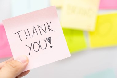 Elinizde pembe yapışkan bir notla teşekkür mesajı var. Boşluğu kopyala.