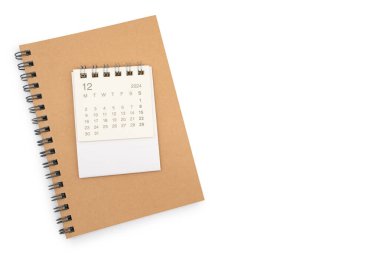 Aralık 2024, 2024 yılı için aylık masa takvimi ve beyaz arkaplanda izole edilmiş not defteri.