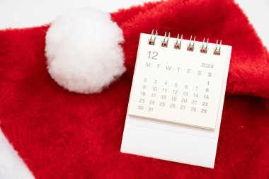 Aralık 2024 'te, beyaz arka planda Noel Baba şapkaları olan basit bir masa takvimi. Kopya alanı ile yeni yıl takvimi kavramı. 2024 Aralık takvimi.