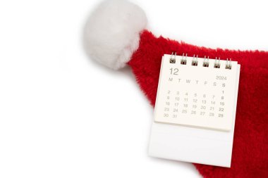 Aralık 2024 'te, beyaz arka planda Noel Baba şapkaları olan basit bir masa takvimi. Kopya alanı ile yeni yıl takvimi kavramı. 2024 Aralık takvimi.
