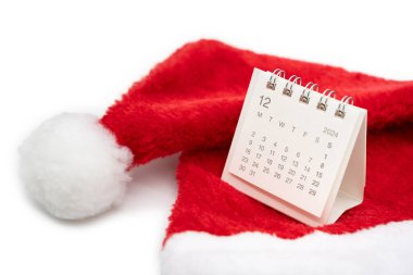 Aralık 2024 'te, beyaz arka planda Noel Baba şapkaları olan basit bir masa takvimi. Kopya alanı ile yeni yıl takvimi kavramı. 2024 Aralık takvimi.