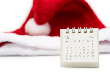 Aralık 2024 'te, beyaz arka planda Noel Baba şapkaları olan basit bir masa takvimi. Kopya alanı ile yeni yıl takvimi kavramı. 2024 Aralık takvimi.