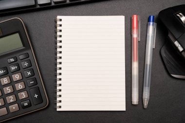 Hesap makinesi ve ofis malzemeleriyle dolu boş bir defter. Uzayı metin için kopyala. Bir yazıt, iş konsepti için yer.