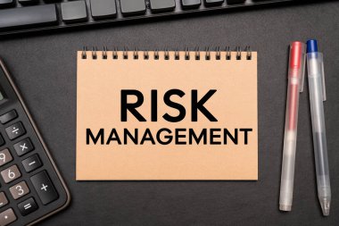 RISK MANAGEMENT hesap makinesi ve ofis malzemeleriyle Not Defteri 'ne mesaj attı. Mali Kriz, Ekonomik, İş Riski Yönetimi.
