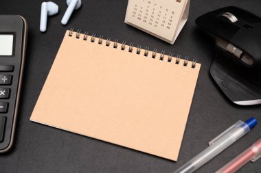 Hesap makinesi ve ofis malzemeleriyle dolu boş bir defter. Uzayı metin için kopyala. Bir yazıt, iş konsepti için yer.