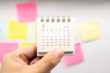 Mart 2025 arkaplanı için el ele tutuşma mini takvimi. Takvim kavramı 2025 MAR takvimi. Yapışkan not