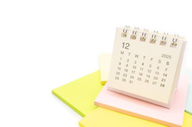 Aralık 2025 için Masa Takvimi. Yapışkan notta 2025 DEC takvimi olan takvim kavramı. beyaz arkaplanda izole.