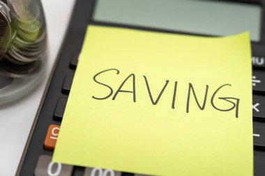 Hesap makinesinde yapışkan notla metin kaydediliyor. finansal konsept. Para biriktirme kavramı. Emeklilik konsepti. Emeklilik hesaplama kavramı.