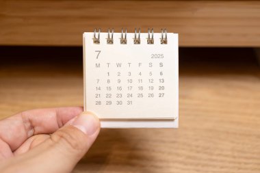 Temmuz 2025 arka planı için Masa Takvimi. Takvim kavramı ahşap arkaplanda 2025 JUL takvimi.