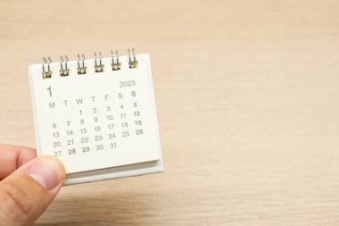 2025 Ocak takvimi için el ele tutuşmalar. Takvim kavramı. Ahşap arka planda 2025 JAN takvimi. Metin için Boşluğu Kopyala.
