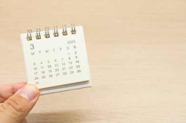 Mart 2025 için el ele tutuşma mini takvimi. Takvim kavramı, 2025 MAR takvimi ile ahşap arka planda. Metin için Boşluğu Kopyala.