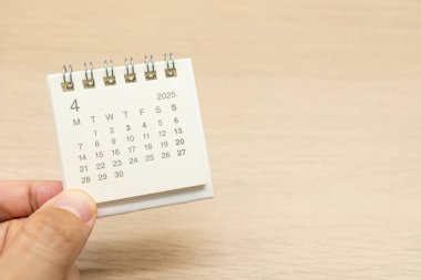Nisan 2025 arka planı için el ele tutuşmalar. Takvim kavramı, ahşap arka planda 2025 APR takvimi. Metin için Boşluğu Kopyala.