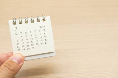 Temmuz 2025 arka planı için el ele tutuşma mini takvimi. Takvim kavramı ahşap arka planda 2025 JUL takvimi. Metin için Boşluğu Kopyala.