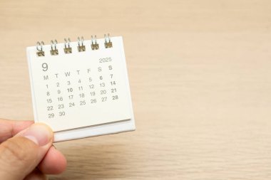 Eylül 2025 arkaplanı için mini takvim tutuyor. Takvim kavramı, ahşap arka planda 2025 SEP takvimi. Metin için Boşluğu Kopyala.