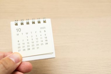 ECTOBER 2025 arka planı için mini takvim tutuyor. Takvim kavramı, ahşap arka planda 2025 OCT takvimi. Metin için Boşluğu Kopyala.