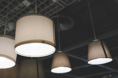 Modern kolye ışıkları karanlık bir tavandan sarkıyor. Boşluğu kopyala.