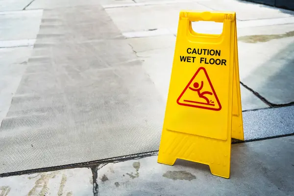 Sarı Dikkat ıslak zeminde kaygan zemin tabelası. Halka açık alanda güvenlik uyarısı. Güvenlik Uyarısı Konsepti.