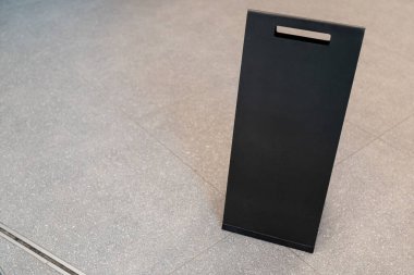 Döşemede Minimalist Siyah Boş İşaret Panosu. Tasarım ya da Mesaj Yerleştirme için Boş Reklam Model 'i. Asgari siyah ayakta tabela.