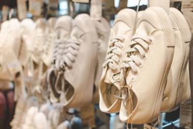 Moda Perakende Mağazasında Gösterilen Klasik Kanvas Spor Ayakkabıları. Modern moda mağazasında düzgünce asılı birkaç çift tuval spor ayakkabısı. Modayla ilgili konular için ideal.