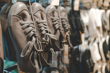 Moda Perakende Mağazasında Gösterilen Klasik Kanvas Spor Ayakkabıları. Modern moda mağazasında düzgünce asılı birkaç çift tuval spor ayakkabısı. Modayla ilgili konular için ideal.