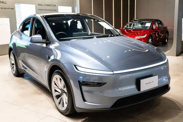 Stüdyoda yeni Tesla Model Y Juniper 2025, galeride elektrikli araç, açık bar.