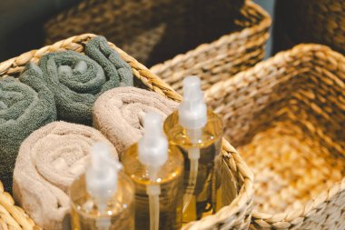 Havlular ve dokuma sepetlerinde sıvı sabun şişeleri olan kaplıca malzemeleri. Sakin, temiz ve rahatlatıcı bir atmosfer. Sağlık, spa ya da banyo dekorasyonu için mükemmel..