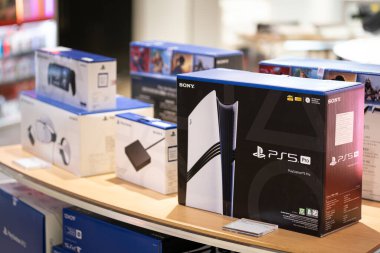 PlayStation 5 oyun konsolu büyük bir mağazada sergileniyor. Alışveriş merkezinde satılık PS5 konsolu.
