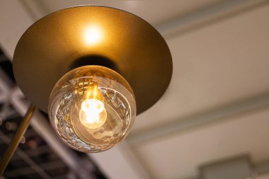 Modern Fixture 'da Ilık Işıltılı Klasik Ampul. Modern bir metal lamba armatürünün içinde parlayan, klasik bir Edison ampulü. İç dekorasyon, ışıklandırma tasarımı, enerji ve rahat atmosferler..