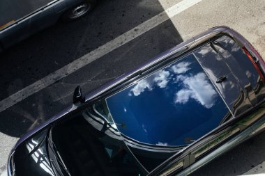 Gökyüzü ve Bulutlar Araba Çatısı 'na yansıyor. Mavi gökyüzünü yansıtan güzel bir görüntü. Sürdürülebilirlik ve Çevre Koruma. İklim değişikliği, yenilenebilir enerji, çevre dostu yaşam, sosyal sorumluluk.