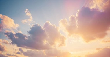 Altın saat boyunca gökyüzünün panoramik görüntüsü, ılık güneş ışığıyla aydınlanan tüylü beyaz ve gri bulutlar.