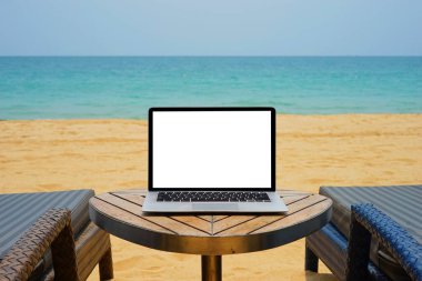 Deniz ve kumsal arka planında yaratıcı tasarım için boş ekranı olan dizüstü bilgisayar. Şimdiki iniş sayfası tasarımı için ekran kırpma yolu olan bilgisayar defteri. Dizüstü bilgisayar şablonu oluşturur