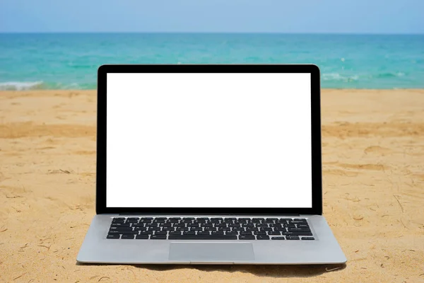 近くの青い海の背景に砂のビーチで創造的なデザインのための空白の画面でノートパソコンを閉じます 現在のランディングページデザインのためのモニタークリッピングパスを持つコンピュータノートブック Mokupテンプレート — ストック写真