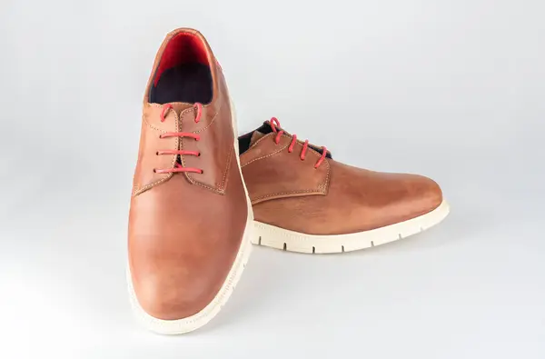 Beyaz arka planda açık kahverengi erkek deri ayakkabıları.