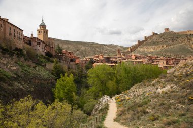 Albarakin, dağ manzarasında çan kulesi ve duvarları olan ortaçağ köyü.
