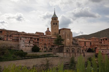Albarracin köyünde antik terracotta binalarıyla çevrili çan kulesi olan tarihi tepe kilisesi.