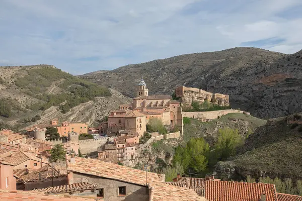 Dağlık vadide yerleşmiş, güçlendirilmiş ortaçağ köyünün panoramik manzarası.
