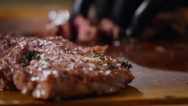 在厨房桌子上用小刀直接从格栅上切出的新鲜多汁烤牛排的特写镜头 — 图库视频影像