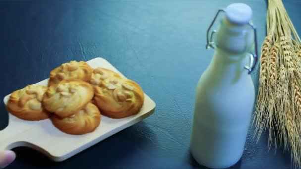在一瓶牛奶旁边放上杏仁和腰果 并在桌上放上顶部皮革的砂轮 作为奶油饼干 还选了一块饼干 — 图库视频影像